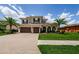 Stunning two-story home featuring a three-car garage, arched entryway, and professionally landscaped yard at 29038 Picana Ln, Wesley Chapel, FL 33543