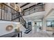 Spacious foyer featuring a staircase with iron railing, soaring ceilings, and elegant tile flooring at 29038 Picana Ln, Wesley Chapel, FL 33543