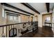 Elegant hallway with dark wood floors, architectural ceiling, and wrought iron railing at 29038 Picana Ln, Wesley Chapel, FL 33543