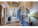Elegant hallway with decorative mirrors, stone accents, unique lighting, and tile flooring at 29038 Picana Ln, Wesley Chapel, FL 33543