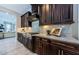 Kitchen with dark wood cabinets, stainless steel appliances, and a marble backsplash, with sightlines to the living room at 29038 Picana Ln, Wesley Chapel, FL 33543