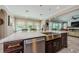 A kitchen island with a stainless steel sink and dishwasher, with views to a sitting area and backyard at 29038 Picana Ln, Wesley Chapel, FL 33543