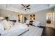 Luxurious main bedroom with tray ceiling, stylish furniture, and ensuite bathroom entrance at 29038 Picana Ln, Wesley Chapel, FL 33543