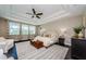 Spacious main bedroom with tray ceiling, a ceiling fan, and three windows overlooking the lanai at 29038 Picana Ln, Wesley Chapel, FL 33543