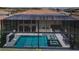 Aerial view of a screened-in pool area with a spa, sun loungers, and a tile roof at 29038 Picana Ln, Wesley Chapel, FL 33543