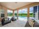 Covered lanai with modern furniture overlooks a serene pool and spa area with lush green landscaping at 29038 Picana Ln, Wesley Chapel, FL 33543