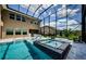 Beautiful screened pool area features a hot tub, outdoor bar, and plenty of space for entertaining at 29038 Picana Ln, Wesley Chapel, FL 33543