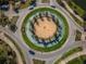 Aerial view of a beautifully landscaped roundabout with trees and water features at 29038 Picana Ln, Wesley Chapel, FL 33543
