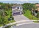 Aerial view of a well-maintained two-story home with a paved driveway and lush green backyard at 30326 Ceasar Park Dr, Wesley Chapel, FL 33543