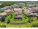 Aerial view of the landscaped backyard with a covered patio and lush greenery at 30326 Ceasar Park Dr, Wesley Chapel, FL 33543