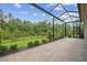 Screened patio with beautiful backyard views and a brick paved floor at 30326 Ceasar Park Dr, Wesley Chapel, FL 33543