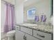 Bathroom featuring a granite countertop, undermount sink, toilet, shower with curtain, and a window at 30326 Ceasar Park Dr, Wesley Chapel, FL 33543