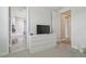 Neutral bedroom showcasing a dresser with a TV and doorway to a bathroom at 30326 Ceasar Park Dr, Wesley Chapel, FL 33543