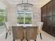 Bright dining area features tile floors, a chandelier, and views of the outdoor greenery at 30326 Ceasar Park Dr, Wesley Chapel, FL 33543