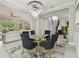 Elegant dining area features a glass table, velvet chairs, and contemporary chandelier at 30326 Ceasar Park Dr, Wesley Chapel, FL 33543