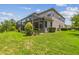 Rear view of the home showcases its screened lanai, well-kept lawn, and manicured landscaping at 30326 Ceasar Park Dr, Wesley Chapel, FL 33543