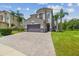 Elegant two-story home featuring a paver driveway, lush landscaping, and a two-car garage at 30326 Ceasar Park Dr, Wesley Chapel, FL 33543