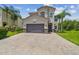Well-maintained home featuring a paver driveway, two-car garage, and manicured landscaping at 30326 Ceasar Park Dr, Wesley Chapel, FL 33543