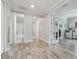 Hallway with wood floors, leading to the bathroom, office, and other rooms in the house at 30326 Ceasar Park Dr, Wesley Chapel, FL 33543