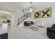 Chic living room featuring an open staircase, designer art, tile flooring, and sophisticated accents at 30326 Ceasar Park Dr, Wesley Chapel, FL 33543