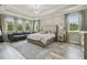 Sun-filled primary bedroom with a seating area, tray ceiling, and ample natural light at 30326 Ceasar Park Dr, Wesley Chapel, FL 33543