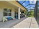 Covered patio boasts brick pavers, outdoor kitchen, and ample seating space for luxurious outdoor living at 30326 Ceasar Park Dr, Wesley Chapel, FL 33543