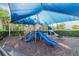 Community playground with blue slides and overhead sun protection at 30326 Ceasar Park Dr, Wesley Chapel, FL 33543