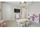 Spacious playroom with a TV, whiteboard, toy kitchen, table with chairs, and neutral carpet at 30326 Ceasar Park Dr, Wesley Chapel, FL 33543