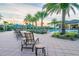 Lounge by the community pool surrounded by lush tropical palms at 30326 Ceasar Park Dr, Wesley Chapel, FL 33543