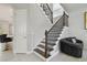 Staircase featuring hardwood stairs, iron banisters, and a decorative wall at 30326 Ceasar Park Dr, Wesley Chapel, FL 33543
