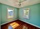 A cozy bedroom featuring bright windows, hardwood flooring, and a ceiling fan at 3110 10Th N Ave, St Petersburg, FL 33713