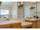 Bathroom vanity featuring dual sinks and a large mirror with decorative sconces at 3262 Westcott Ct, Palm Harbor, FL 34684