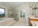 Bathroom showcasing a soaking tub, glass shower, vanity and shuttered window at 3262 Westcott Ct, Palm Harbor, FL 34684