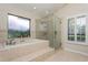 Bright bathroom featuring a soaking tub, glass shower, and shuttered window at 3262 Westcott Ct, Palm Harbor, FL 34684
