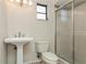 This cozy bathroom includes a pedestal sink, toilet, and glass-enclosed shower at 3262 Westcott Ct, Palm Harbor, FL 34684