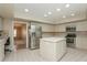 Well lit kitchen with stainless steel appliances, center island, and access to living area at 3262 Westcott Ct, Palm Harbor, FL 34684