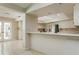 Bright kitchen with a peninsula island, white cabinets, and adjacent breakfast nook with french door access to the sun room at 3262 Westcott Ct, Palm Harbor, FL 34684