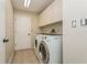 Laundry room with appliances, tile floor, and overhead cabinets for storage at 3262 Westcott Ct, Palm Harbor, FL 34684