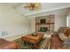 Vaulted ceilings and a brick fireplace add charm to the living room with a ceiling fan and neutral carpet at 3262 Westcott Ct, Palm Harbor, FL 34684