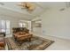 Bright living room with vaulted ceiling, brick fireplace, neutral carpet and view to kitchen and sunroom at 3262 Westcott Ct, Palm Harbor, FL 34684