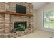 Living room with a brick fireplace and a view of the backyard through the window with white shutters at 3262 Westcott Ct, Palm Harbor, FL 34684