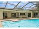 Enjoy this backyard pool with a screened enclosure and brick-paver patio at 3262 Westcott Ct, Palm Harbor, FL 34684