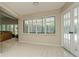 Bright sun room featuring neutral tile flooring, large windows with white shutters, and french doors leading outdoors at 3262 Westcott Ct, Palm Harbor, FL 34684