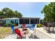 Enjoy outdoor gatherings around the fire pit, surrounded by colorful Adirondack chairs, landscaping, and the screened in porch at 3312 Kenmore Dr, Sarasota, FL 34231