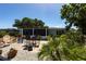 Charming backyard features a brick patio, colorful seating, lush landscaping, and tropical plants at 3312 Kenmore Dr, Sarasota, FL 34231