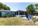 Backyard featuring lush green grass, a gravel area, colorful Adirondack chairs and a screened in porch at 3312 Kenmore Dr, Sarasota, FL 34231