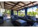 Relaxing covered patio featuring comfortable seating, stylish decor, and a view of the lush backyard at 3312 Kenmore Dr, Sarasota, FL 34231
