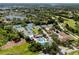 An aerial view showcases tennis courts, a swimming pool, and a clubhouse surrounded by lush trees at 335 Palmdale Dr, Oldsmar, FL 34677
