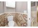 Powder room with tan and brown tiled walls and half bath near tiled bathtub at 335 Palmdale Dr, Oldsmar, FL 34677
