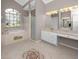Well-lit bathroom featuring tile floors, a garden tub, walk-in shower, and a double vanity at 335 Palmdale Dr, Oldsmar, FL 34677
